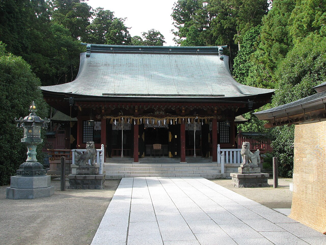 志波彦神社の銅葺き屋根の社殿と参道の狛犬