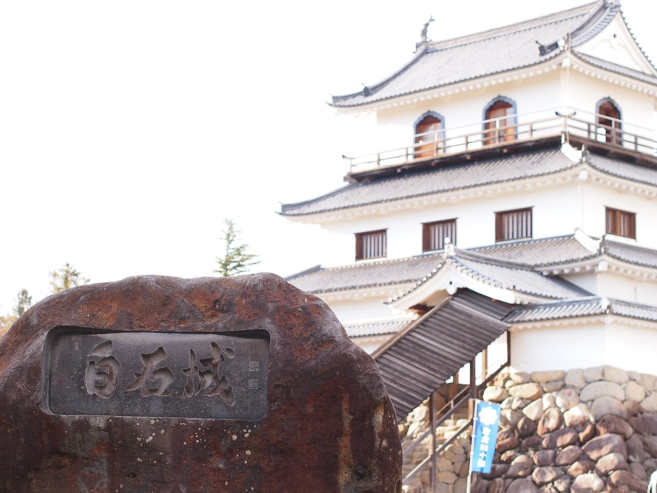 「白石城」と刻まれた石碑と背後にそびえる天守