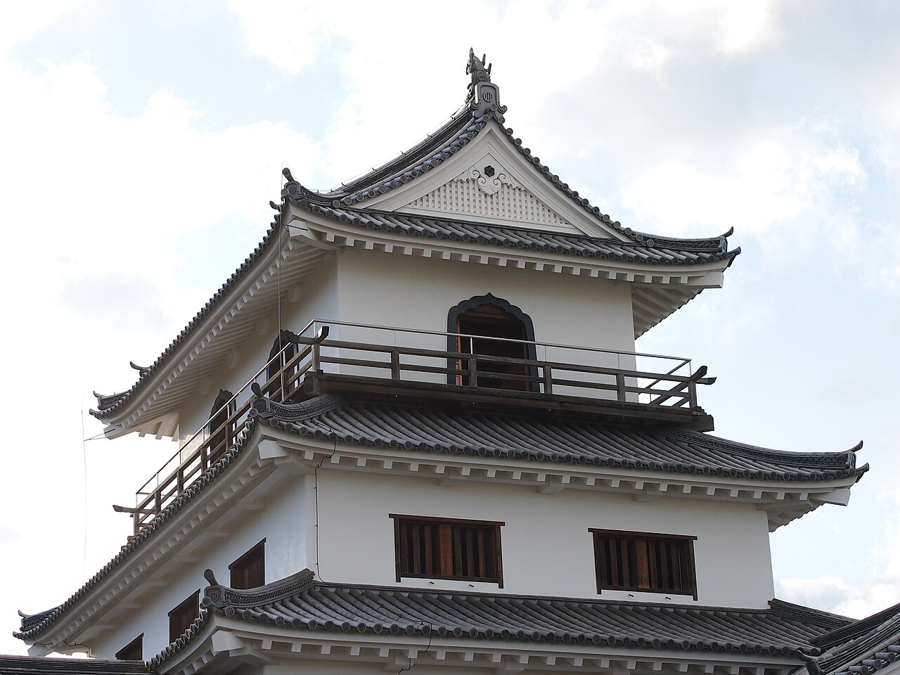 青空を背景にそびえる白石城三階櫓の白壁と黒瓦