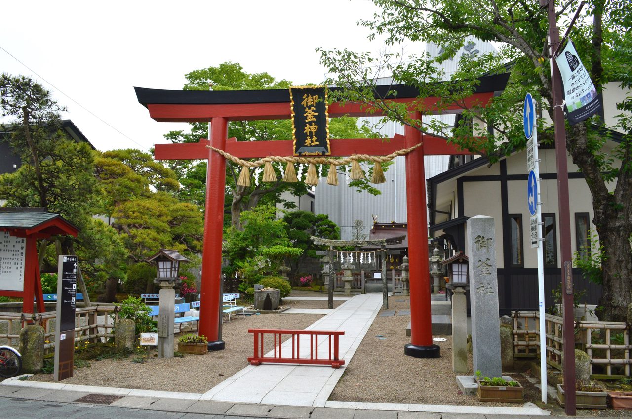 御釜神社の朱塗りの鳥居と「御釜神社」の扁額