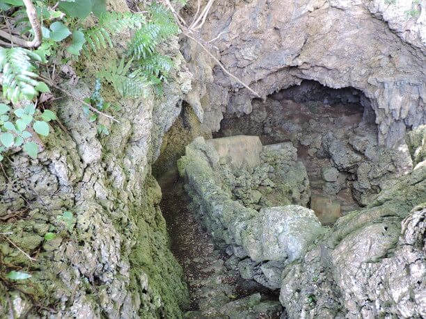 友利のあま井の洞窟内部、苔むした石壁と水路
