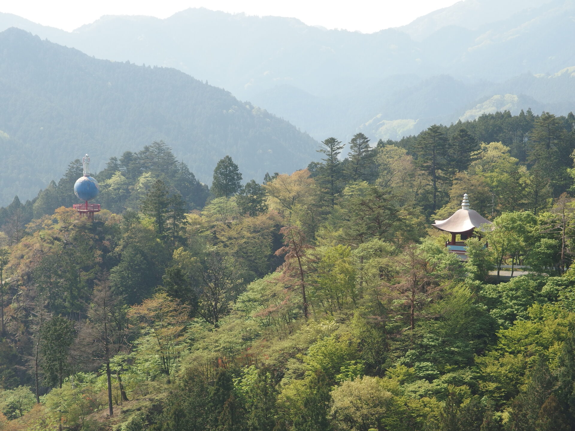 鳥居観音の山頂に置かれた地球儀のモニュメントと山並み