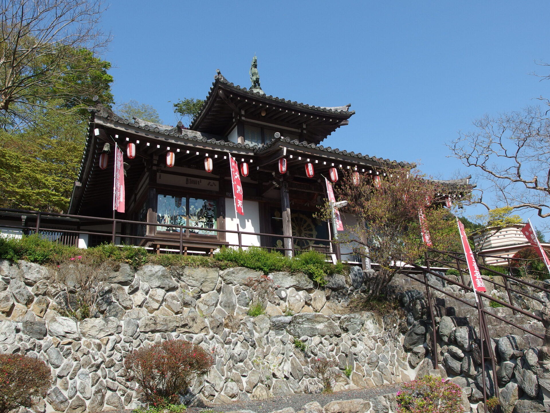 鳥居観音の本堂に並ぶ紅白の提灯と石垣