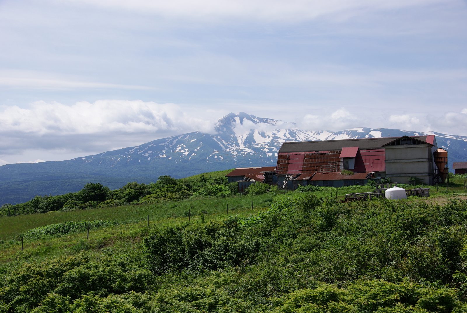 土田牧場の牧舎と雪をいただく鳥海山