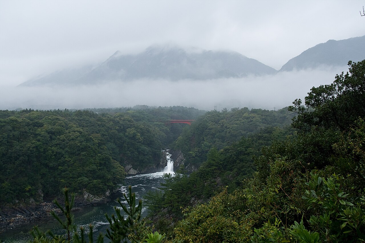 引きで見るトローキの滝と、奥に雲をまとったモッチョム岳