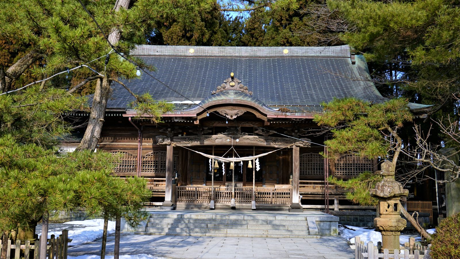 千秋公園の木立に包まれた彌高神社の社殿