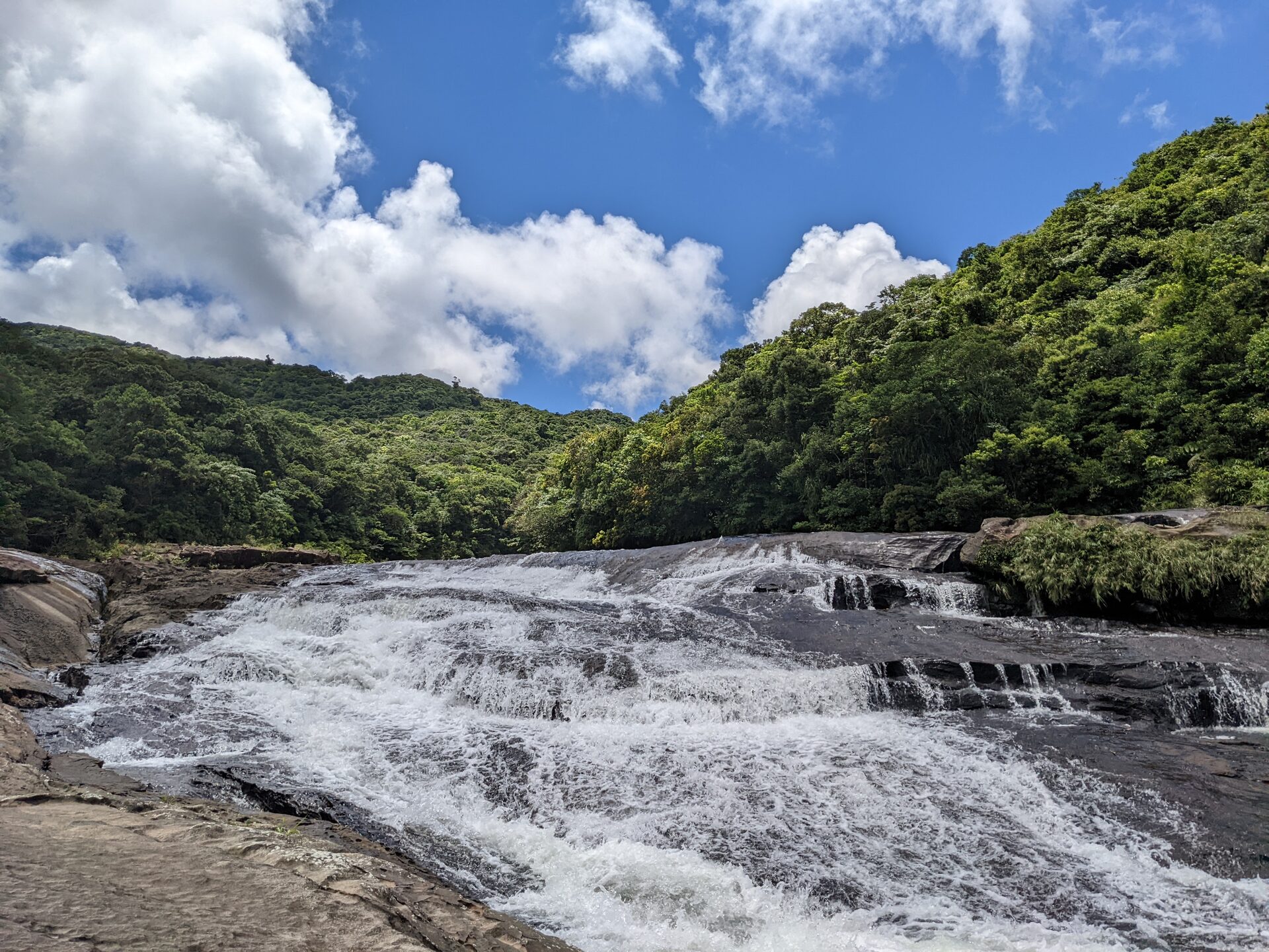 緑の山あいを流れる清流と青空、涼を誘う避暑地の風景
