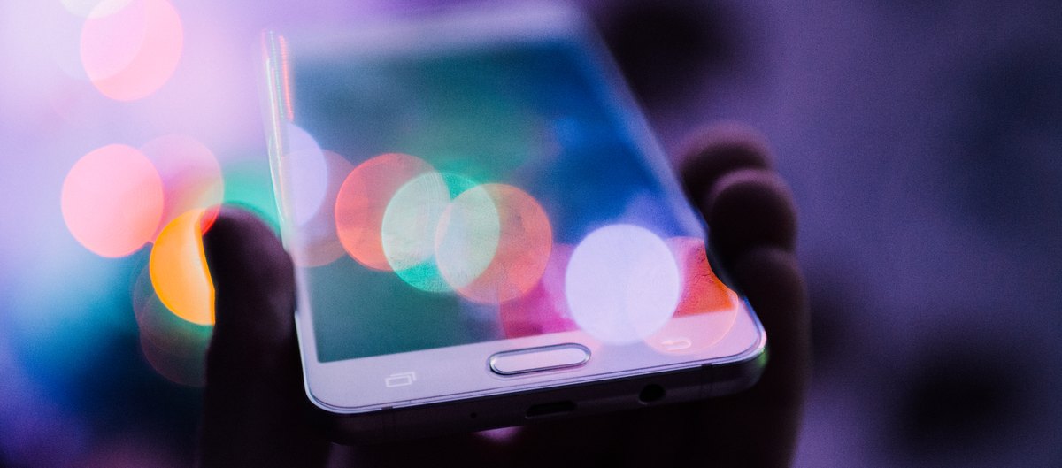 夜の光の中でスマートフォンを持つ手