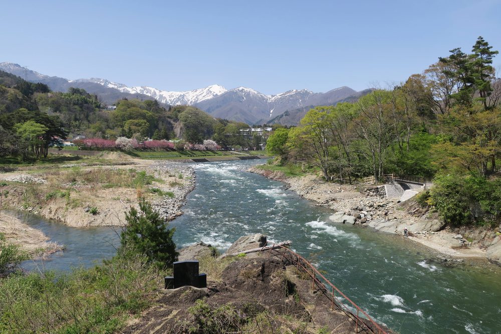 雪をかぶった谷川連峰と利根川の流れ