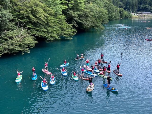 四万湖の青い湖面に浮かぶ、たくさんのSUPボード