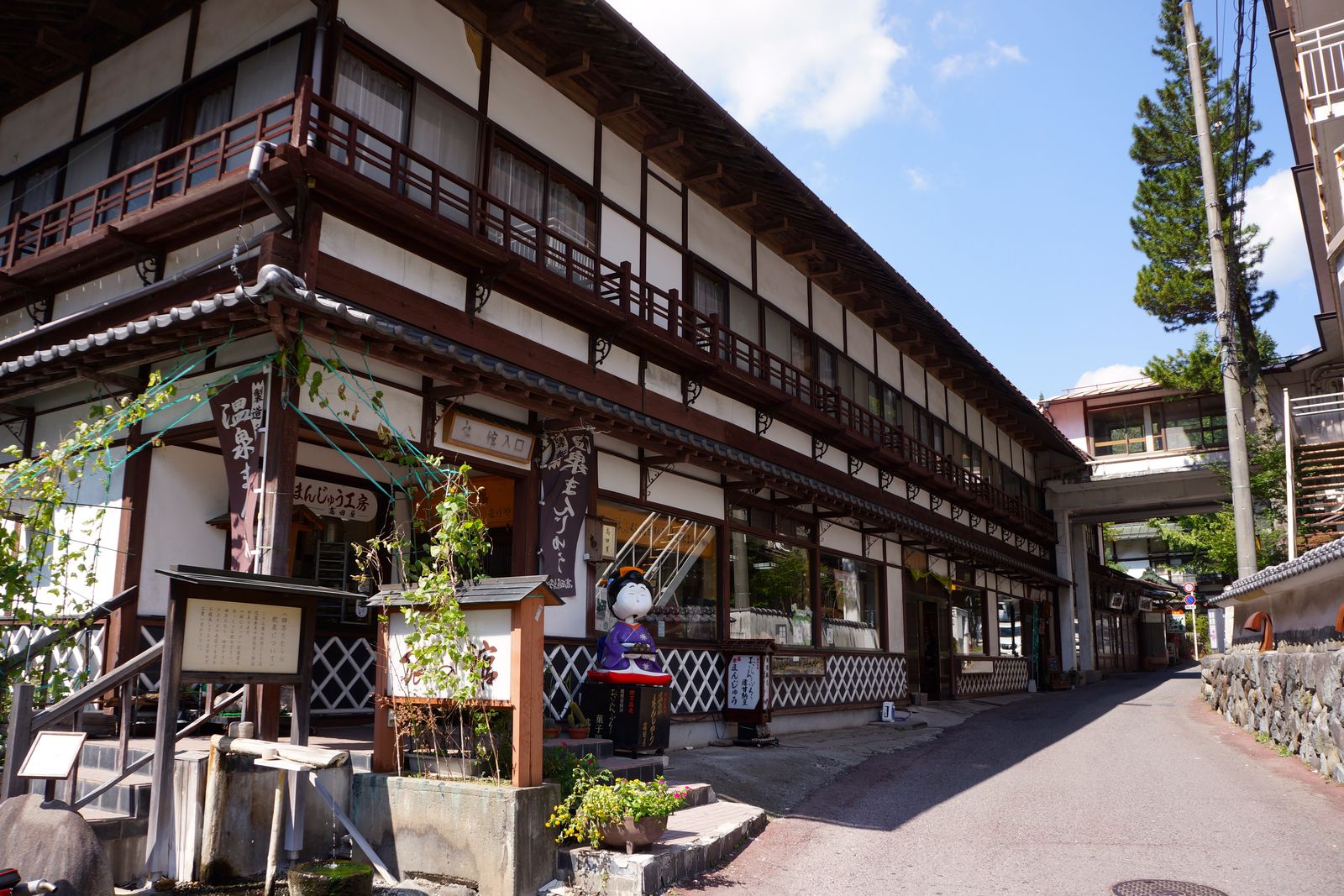 四万温泉の通りに面した木造の温泉まんじゅう店と旅館