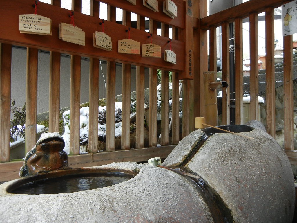 石の水盤に温泉が注がれる四万温泉の飲泉所と柄杓