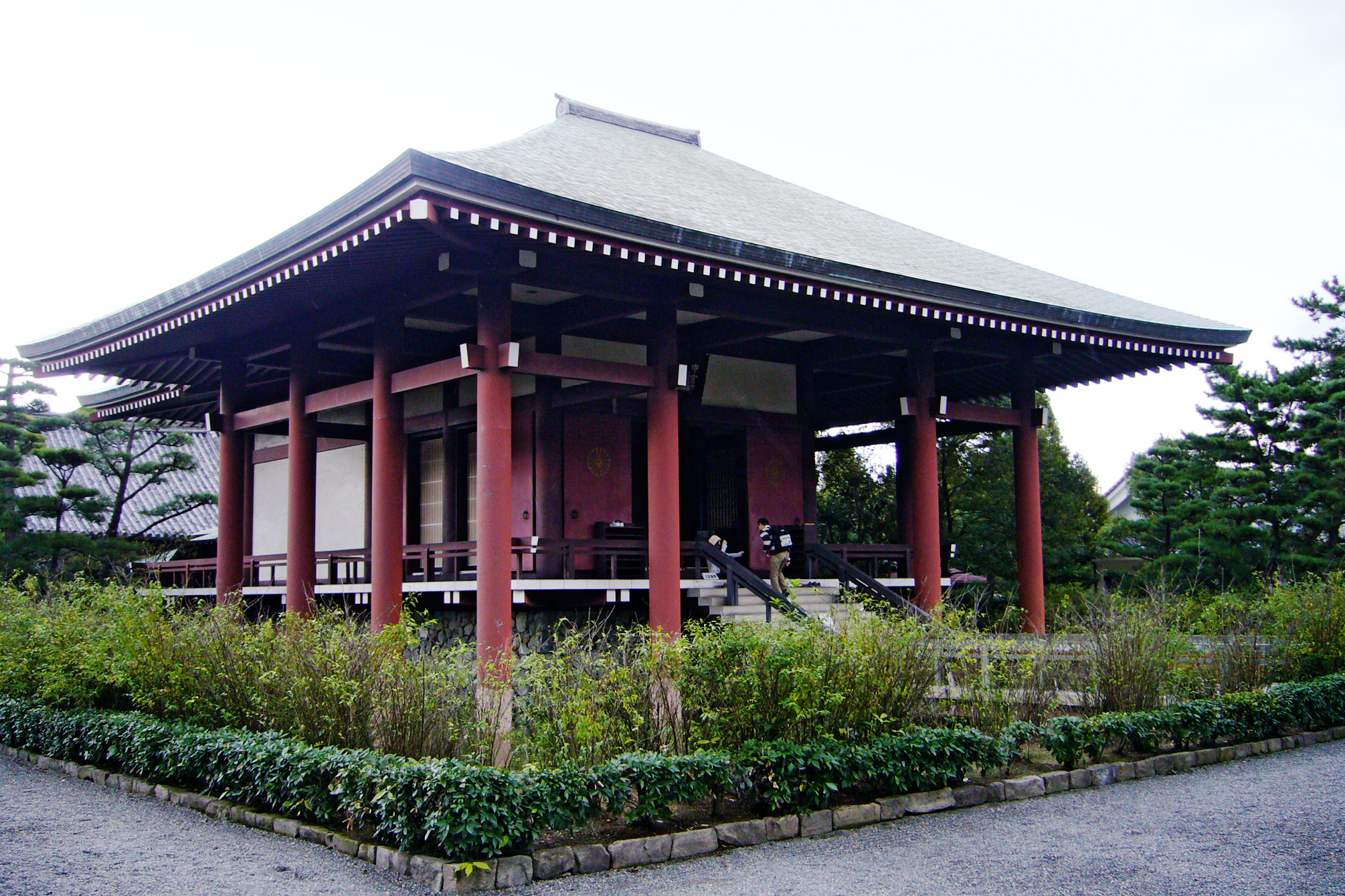 中宮寺の本堂を斜めから望む、朱塗りの丸柱と庭