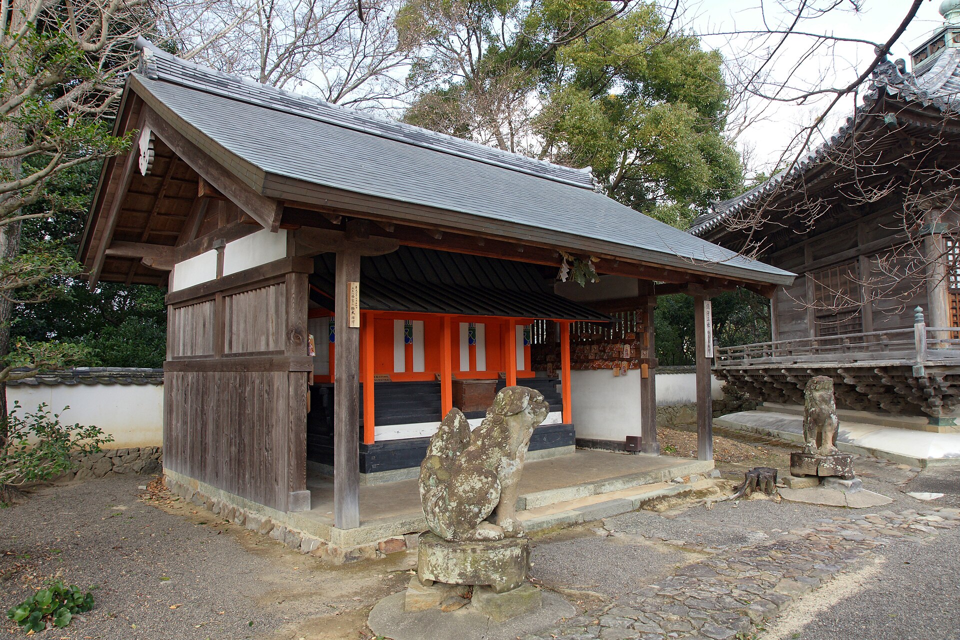 道成寺の境内に建つ朱塗りの鎮守社と狛犬