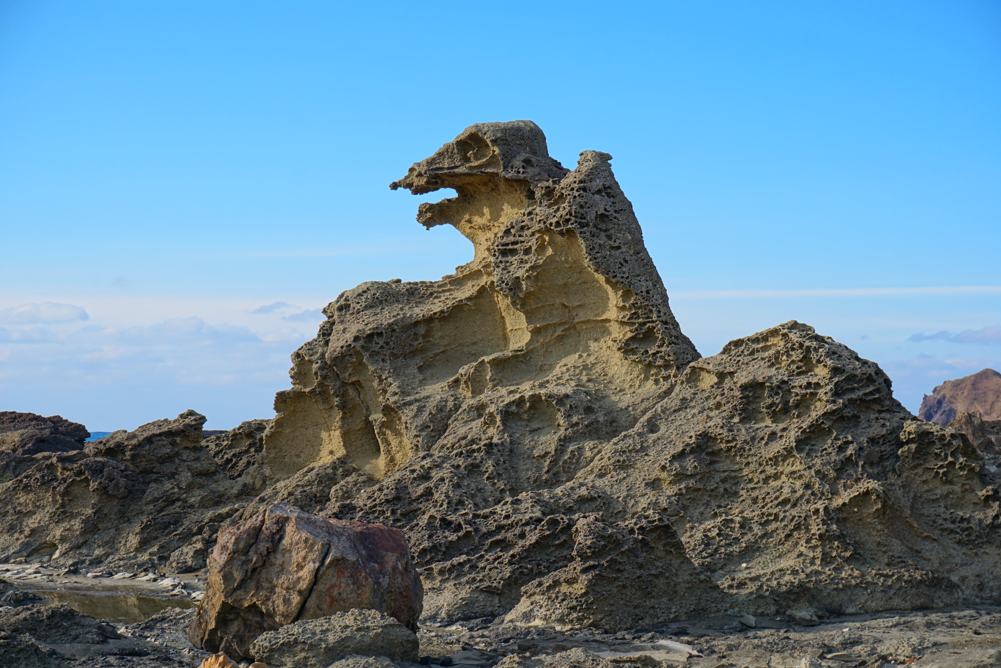 青空の下、火山礫凝灰岩の質感がよくわかるゴジラ岩の日中の姿