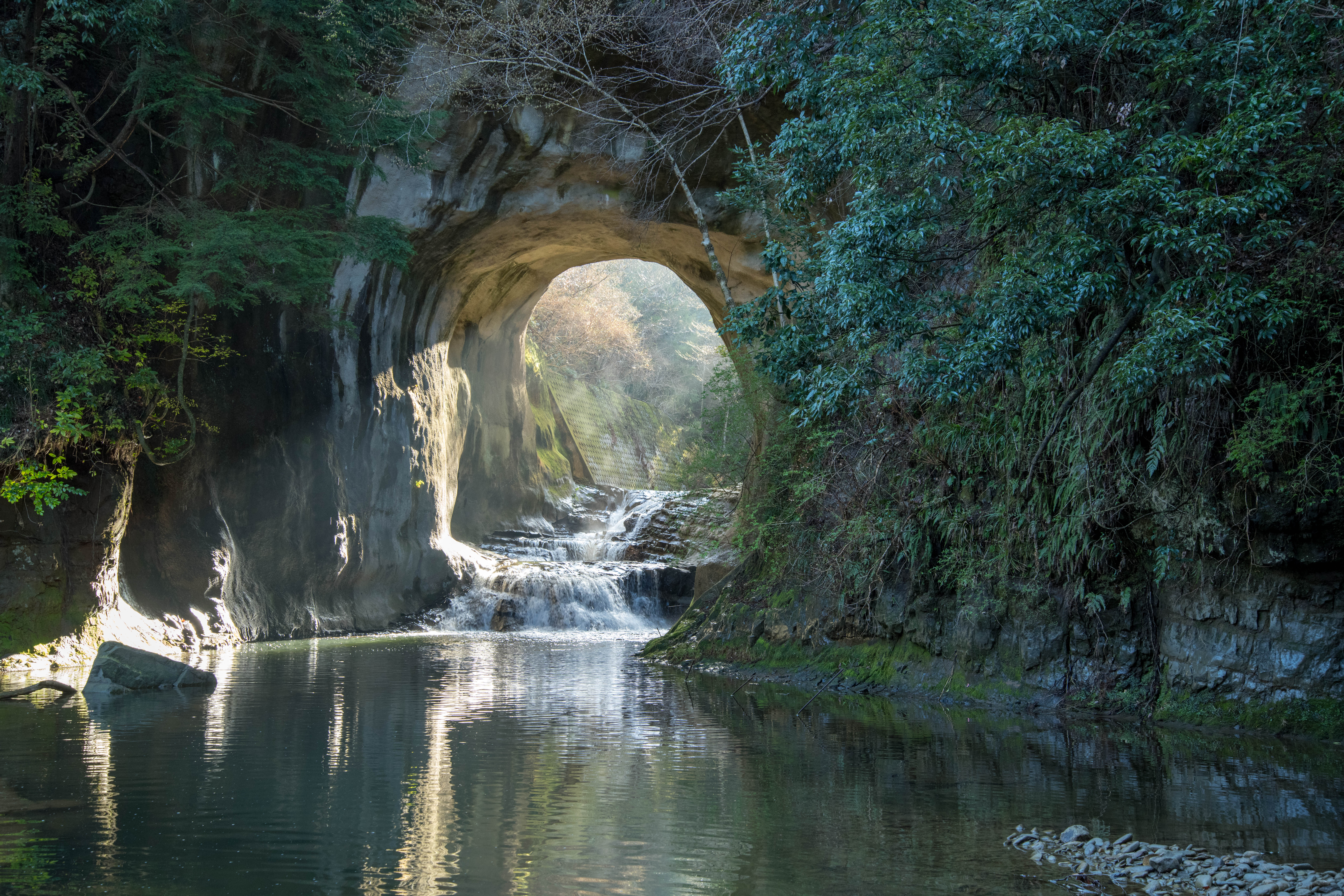 亀岩の洞窟のアーチ状の岩壁と小さな滝