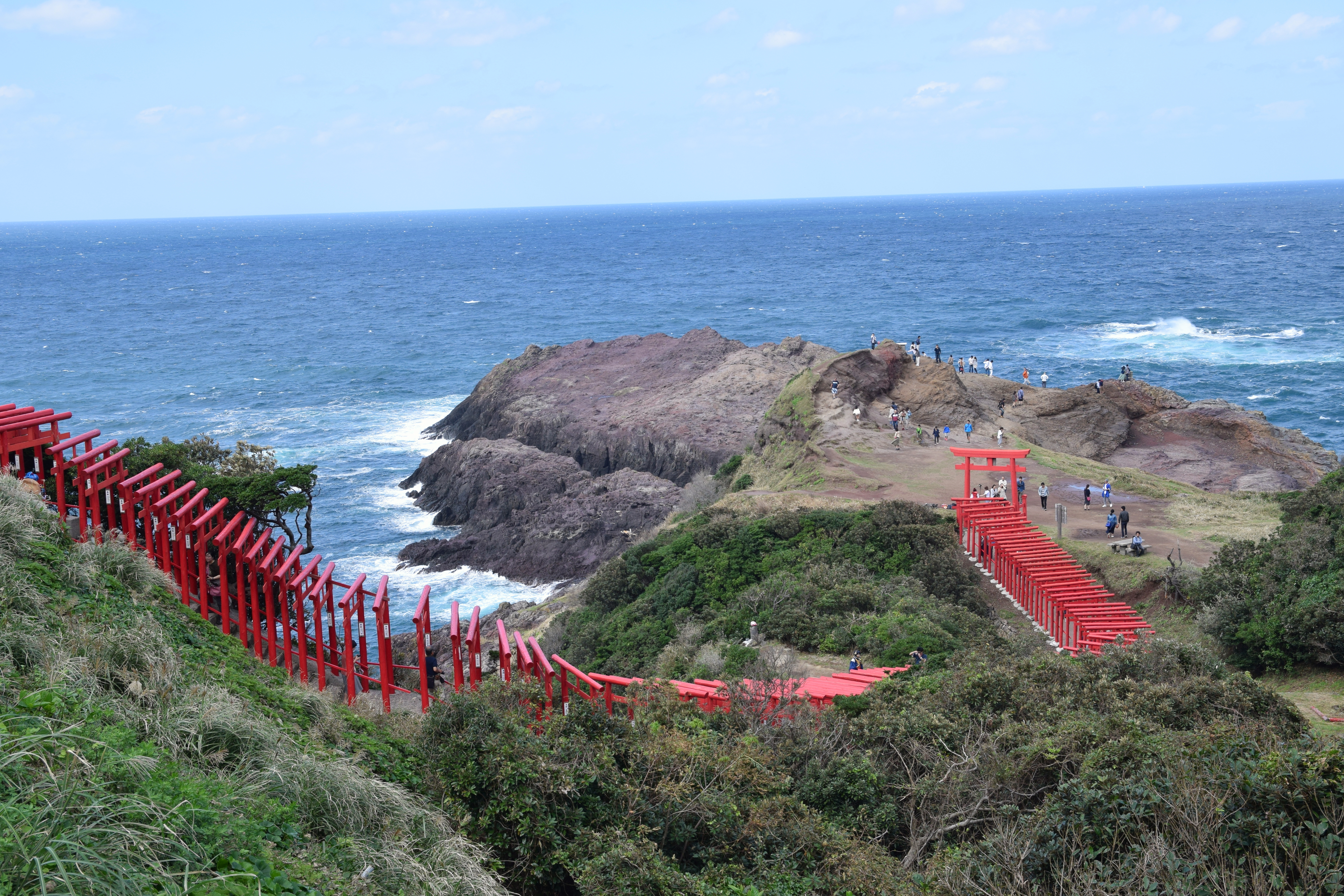 元乃隅神社の赤い鳥居と龍宮の潮吹一帯の岩礁