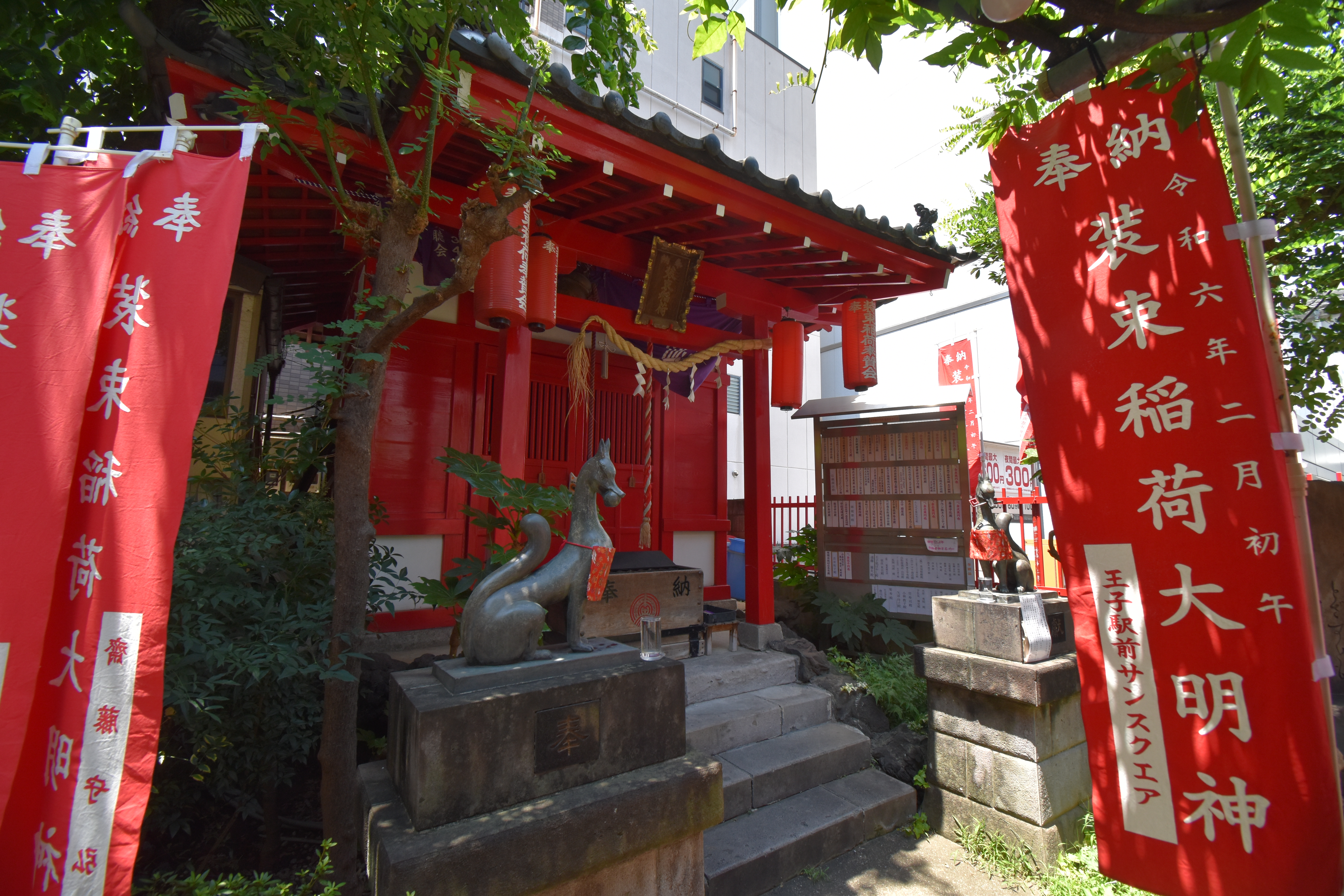 装束稲荷神社の小さな社殿と神狐の像