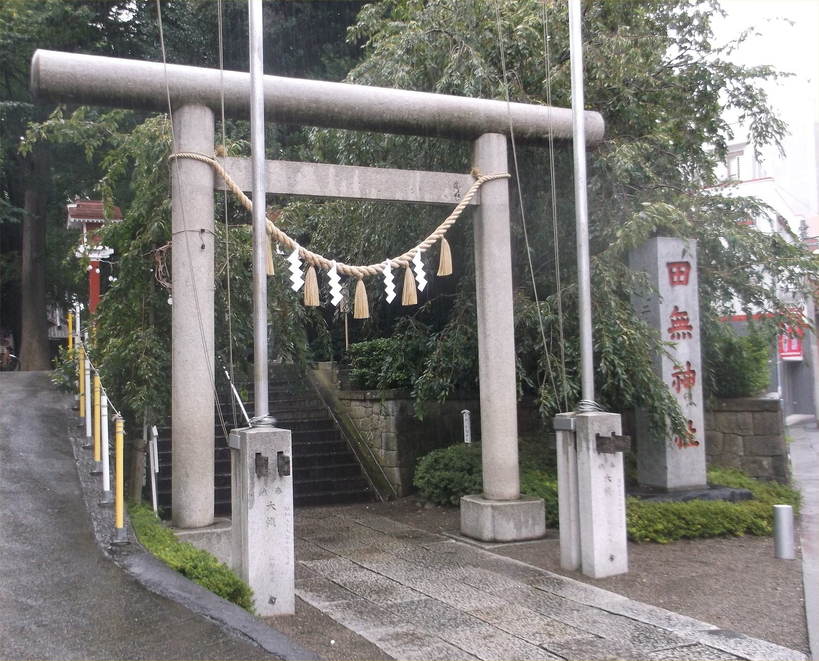 雨の中の田無神社の鳥居と社号標