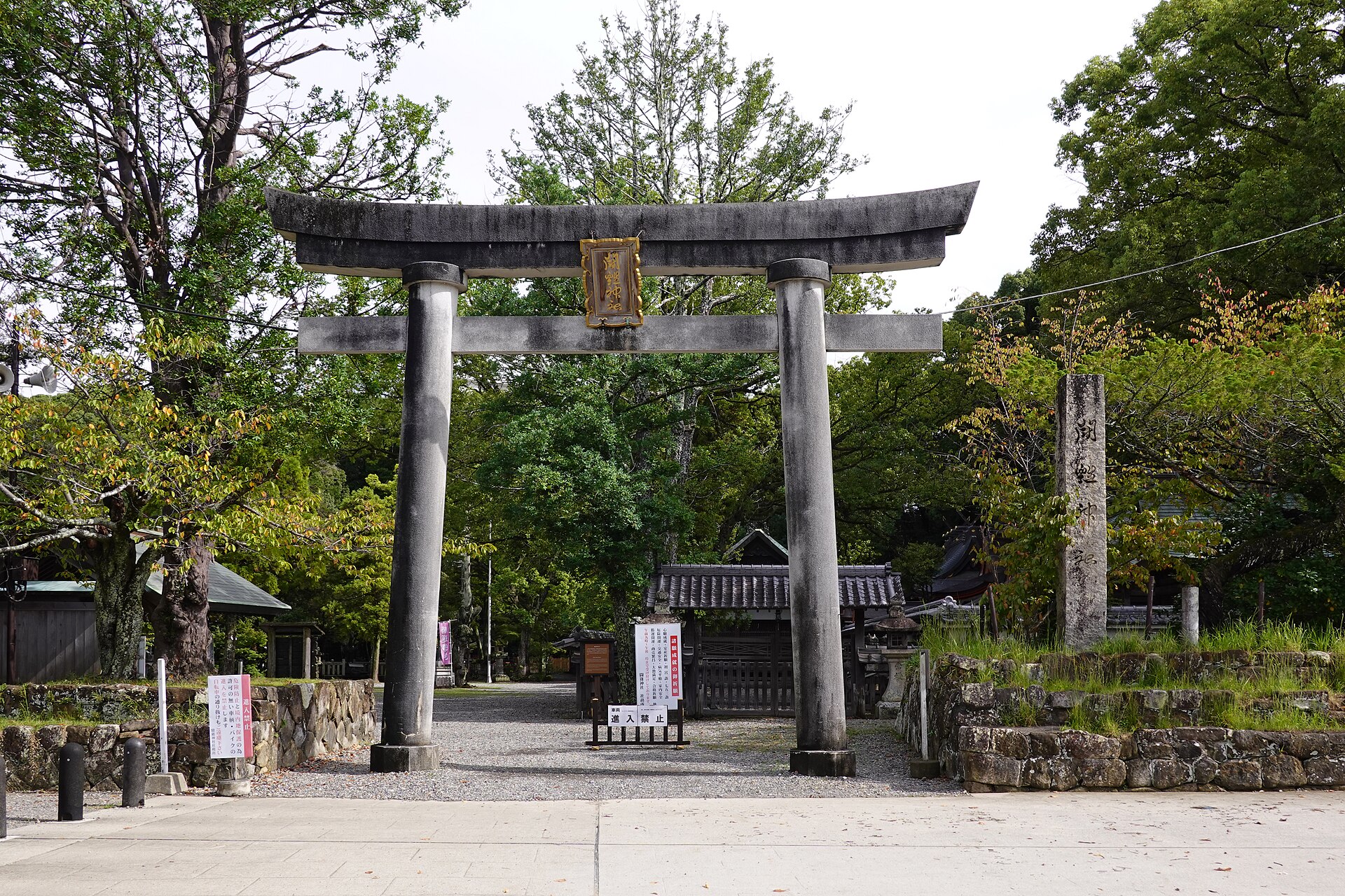闘鶏神社の石造りの鳥居と社号標